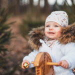 holcicka_jede_na_drevenem_houpacim_koni_a_smeje_se